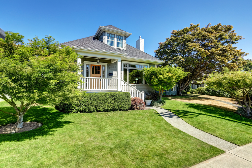 Single-family American craftsman house exterior. Blue sky background and nicely trimmed front yard. Northwest, USA